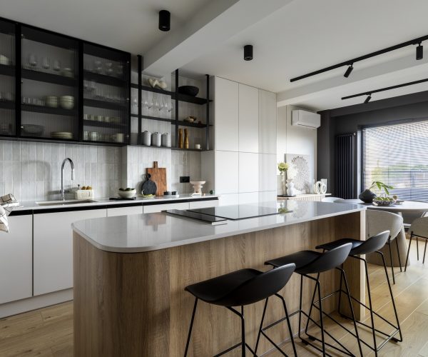 Modern composition of kitchen interior with kitchen island, stylish black chockers, built-in kitchen, glass cabinets, grey table and personal accessories. Home decor. Template.